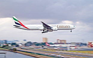 white Emirates Airplane landing during daytime
