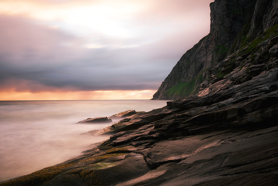 ocean near mountain during daytime HD wallpaper