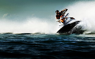 man riding personal watercraft on body of water