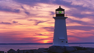 lighthouse near body of water during sunset