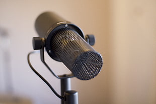 selective focus photography of black condensing microphone