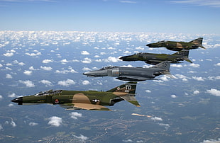 four green and blue camouflage fighter planes above white clouds during daytime HD wallpaper