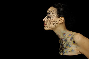 photo of woman with peacock tail paint with black background