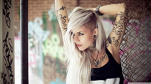 woman in black tank top with tattoo posing