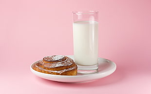 clear highball glass with milk and baked bread on the white ceramic plate