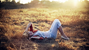 woman lying on brown dried grass field HD wallpaper