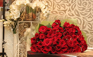 bouquet of red rose on brown wooden table