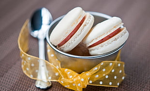 two white macarons in stainless steel bowl