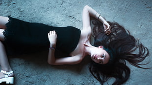 woman in black strapless dress lying down on the floor