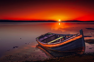 docked boat on shoreline during golden hour