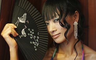 woman holding black and white hand fan