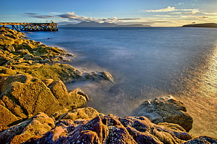 brown stones beside ocean during sunset, arran HD wallpaper