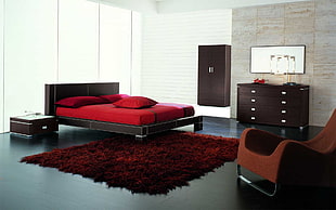 red area rug under black wooden bed frame with red bed mattress