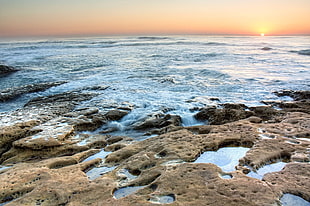 photography of splashing waves on seashore while golden hour, america