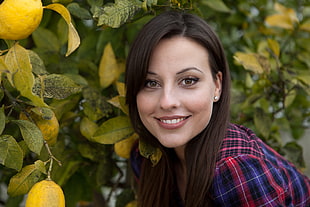 woman in red and blue plaid shirt near green plants during daytime