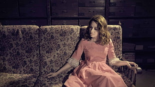 woman in pink dress sitting on the sofa
