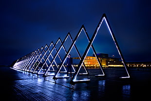 man inside lighted triangular frames during nighttime, copenhagen HD wallpaper