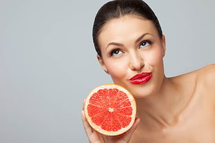 woman holding orange sliced fruit