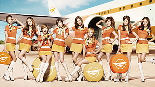 women wearing air stewardess outfits near airplane