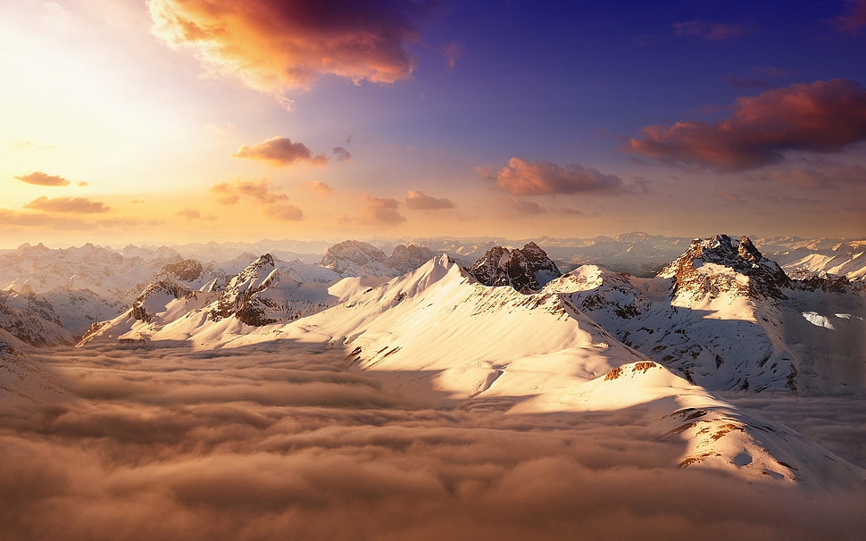 mountain covered with white snow with clouds view during golden hour HD wallpaper