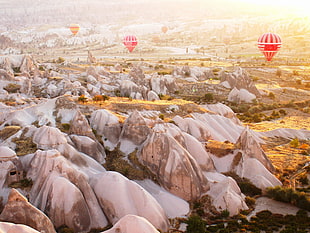 hot air balloon in the air below green grass field and and mountain, cappadocia HD wallpaper