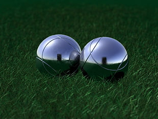 two tennis balls on green grass field during daytime