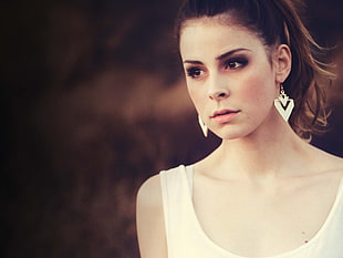 photography of woman in white top and white hook earrings