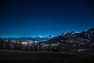 mountain covered with snow under cloudy night sky