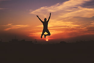silhouette of man jumping during golden hour HD wallpaper