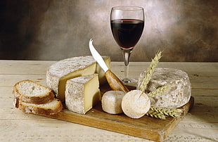 wine glass filled with red wine beside bread