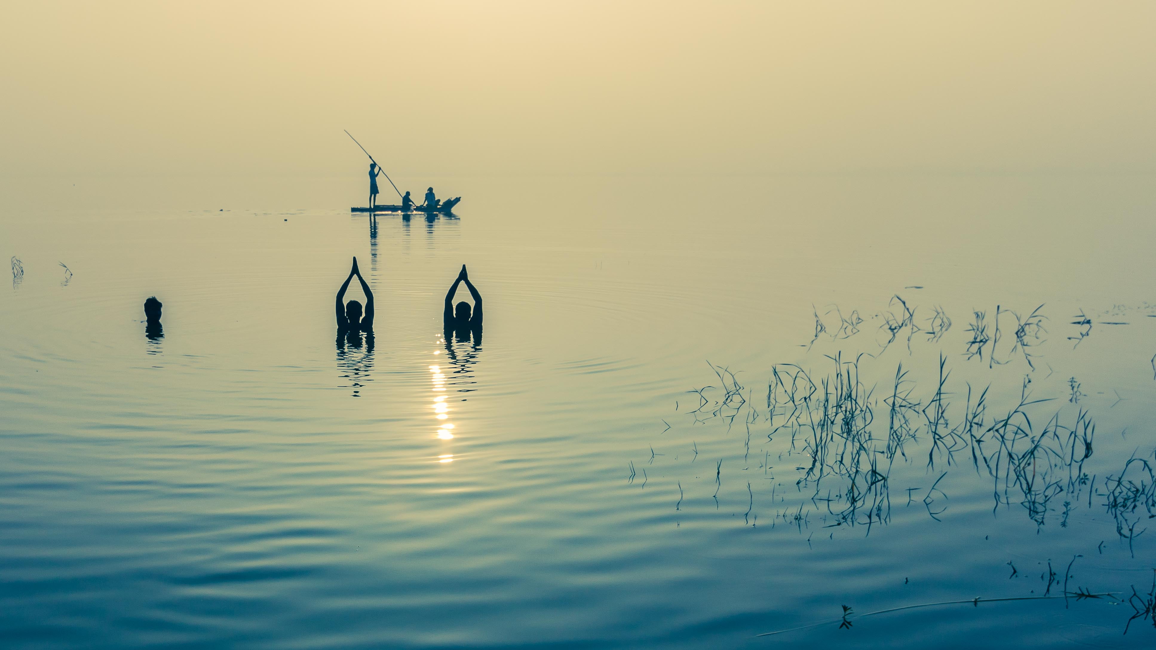 three people at the lake near boat