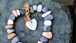 heart-shaped stone in middle of beaded stones on rock