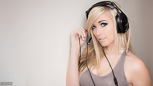 woman wearing gray sleeveless top and black full size corded headset