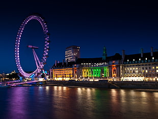 photo of concrete buildings during nighttime, london eye