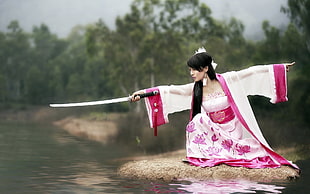 woman wearing white and pink kimono holding black tsuka stainless steel katana