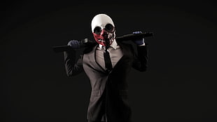man in black suit wearing skeleton mask holding rifle
