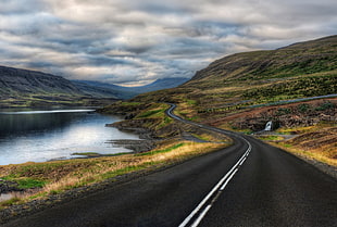 asphalt road surrounded by body of water HD wallpaper