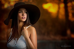 woman in black hat and white spaghetti strap top