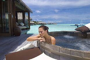 woman wearing black bikini on brown hot tub
