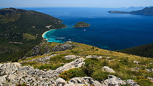 aerial view of green and gray mountain and blue body of water