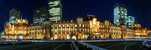 photo of building with yellow lights beside concrete road, tokyo station