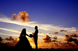 silhouette photo of newlywed couple at golden hour