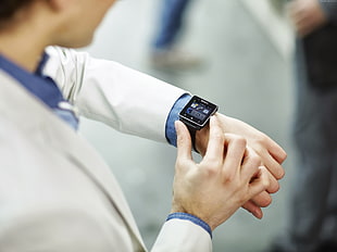 person in grey suit using black smartwatch
