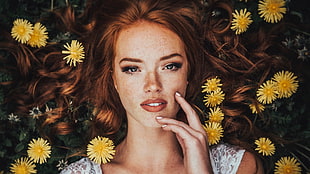 woman in white top laying on yellow flowers during daytime