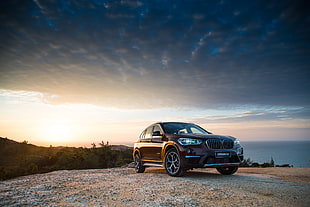 black BMW X5 on mountain during golden hour