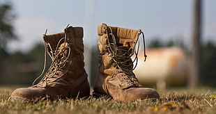 selective focus of jungle boots on grass during daytime