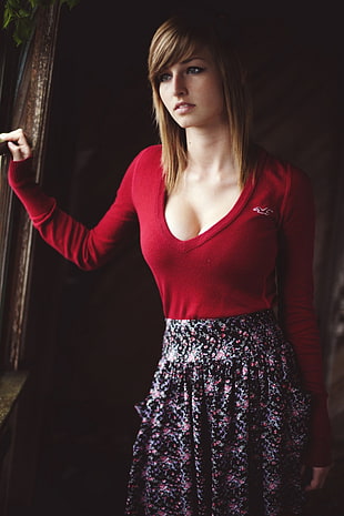 woman in red sweater standing near window HD wallpaper