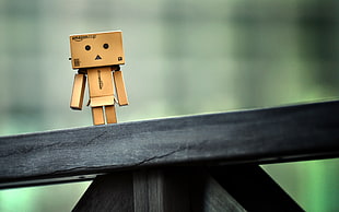 selective focus of cardboard boy on black wooden table HD wallpaper