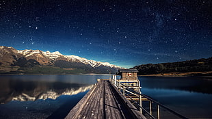 brown wooden dock under starry night