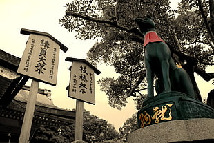 black animal statue and two signboards, statue
